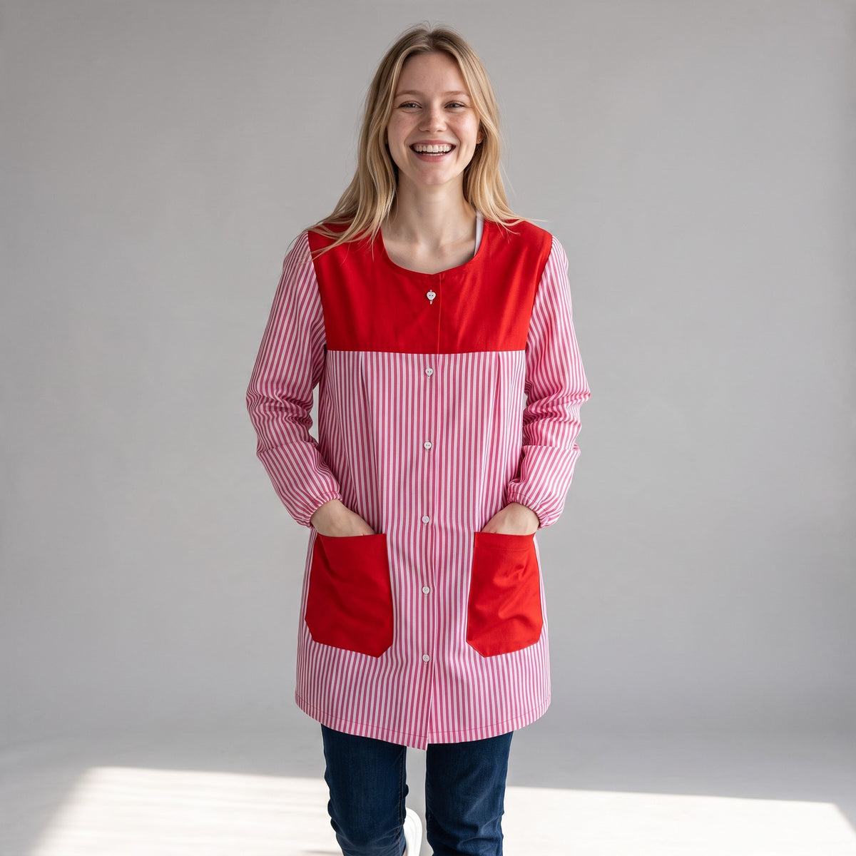 Bata de maestra SuYa Shop a rayas rojas y blancas con bolsillos rojos y cierre de botones, modelo sonriente