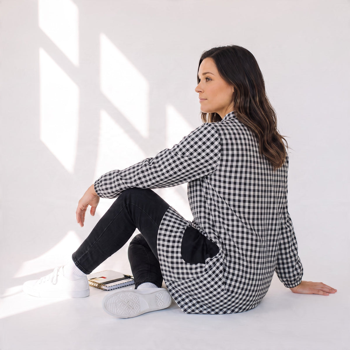 Mujer sentada vistiendo bata SuYa Shop de cuadros vichy en blanco y negro con mangas largas y estilo casual