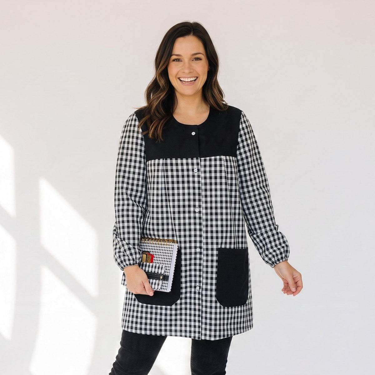 Mujer sonriente vistiendo bata SuYa Shop de cuadros vichy en blanco y negro con bolsillos y mangas largas