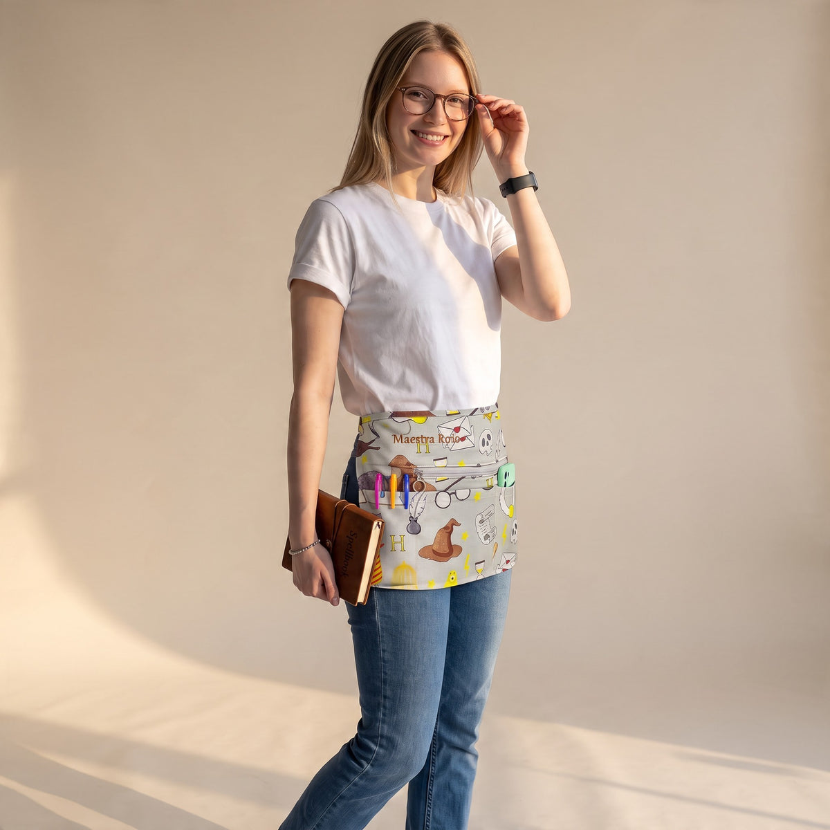 Mujer con camiseta blanca y vaqueros usando un mandil SuYa Shop con estampado de temática mágica y bolsillos