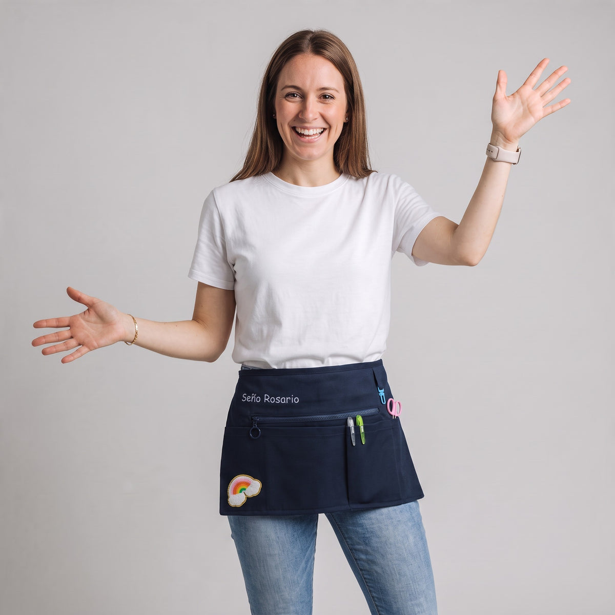 Profesora sonriente vistiendo un mandil vaquero azul marino personalizado de SuYa Shop con parche de arcoíris