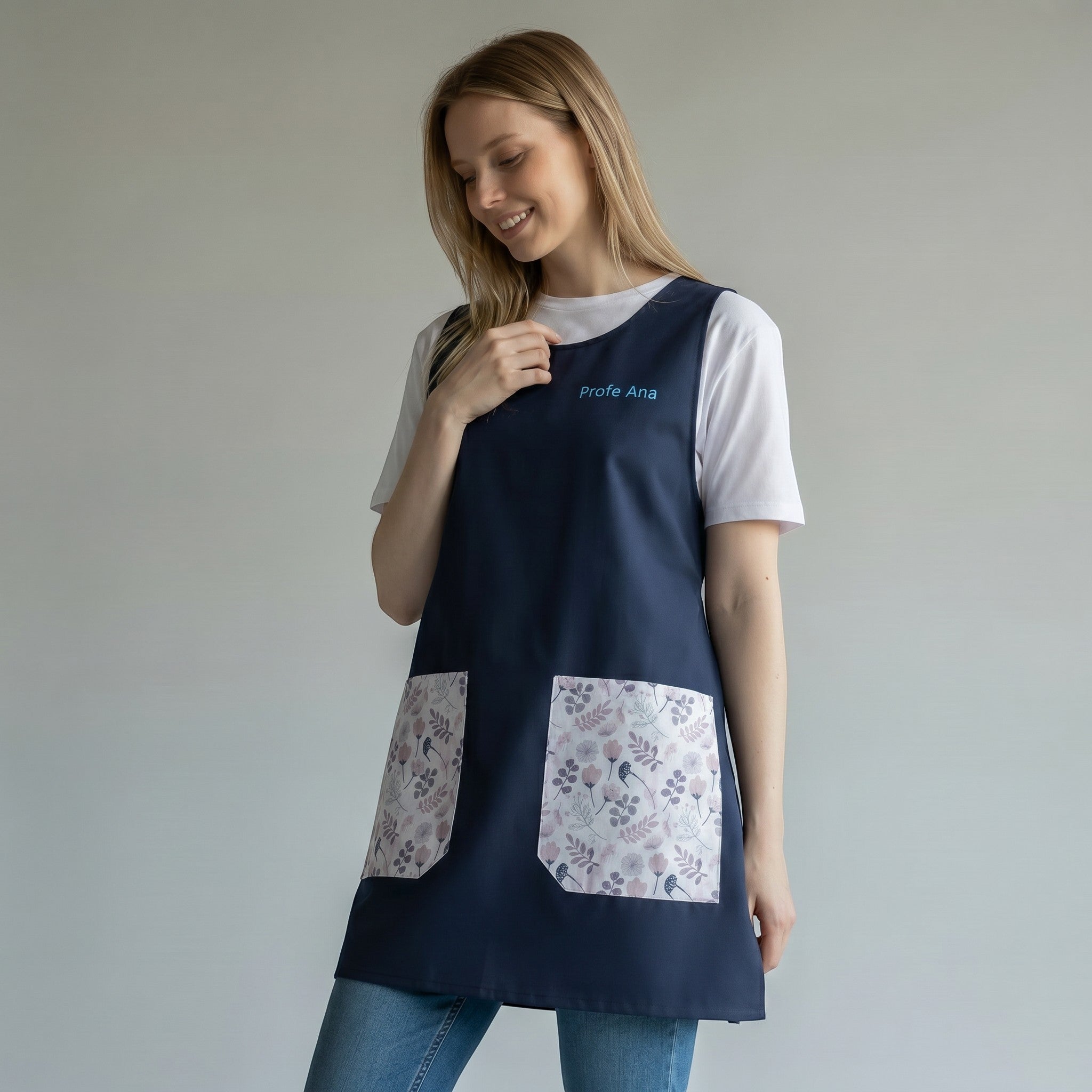 SuYa Shop navy blue teacher smock with floral pockets and personalized embroidery worn by a smiling woman
