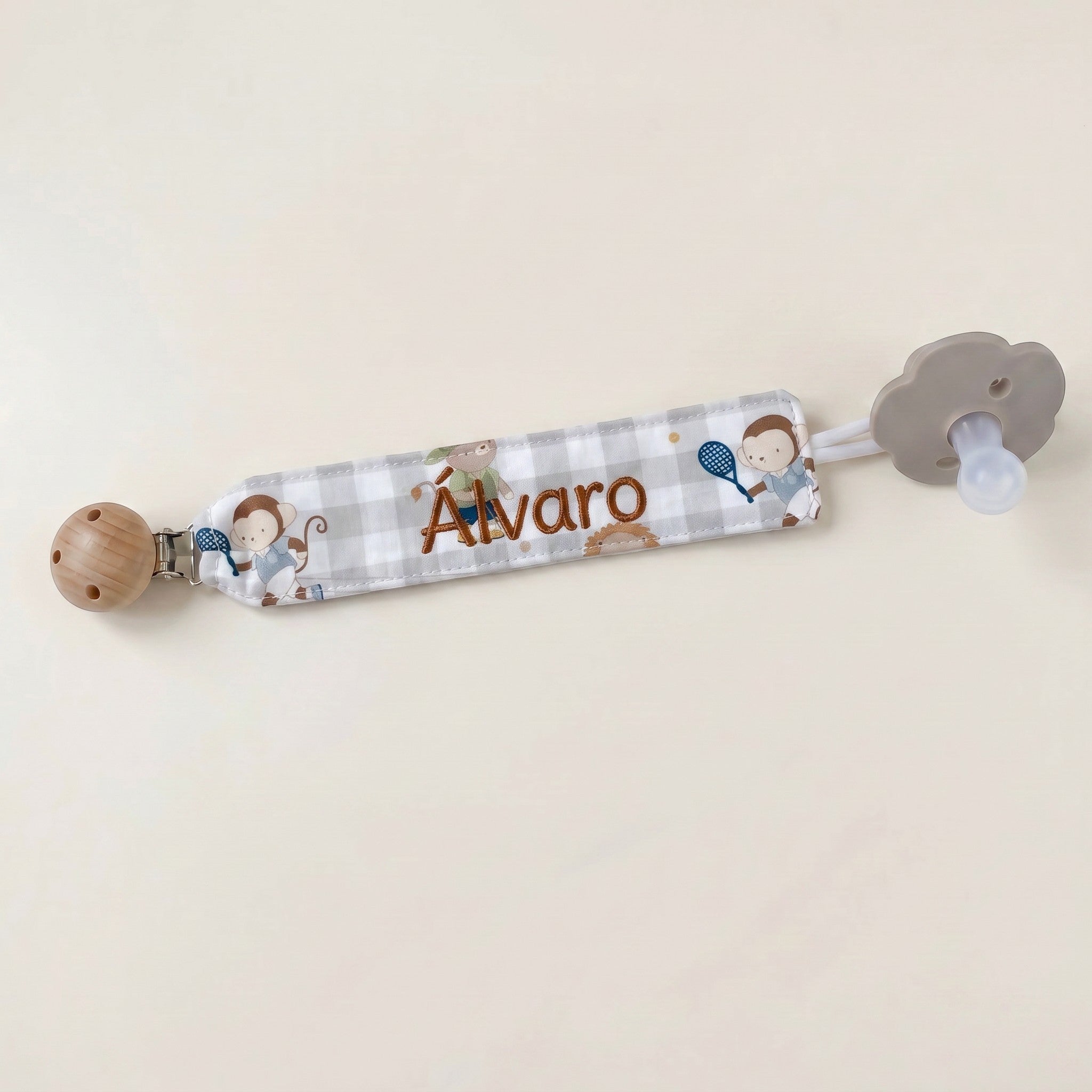 SuYa Shop personalized grey gingham pacifier clip featuring monkey tennis print and embroidered name Alvaro