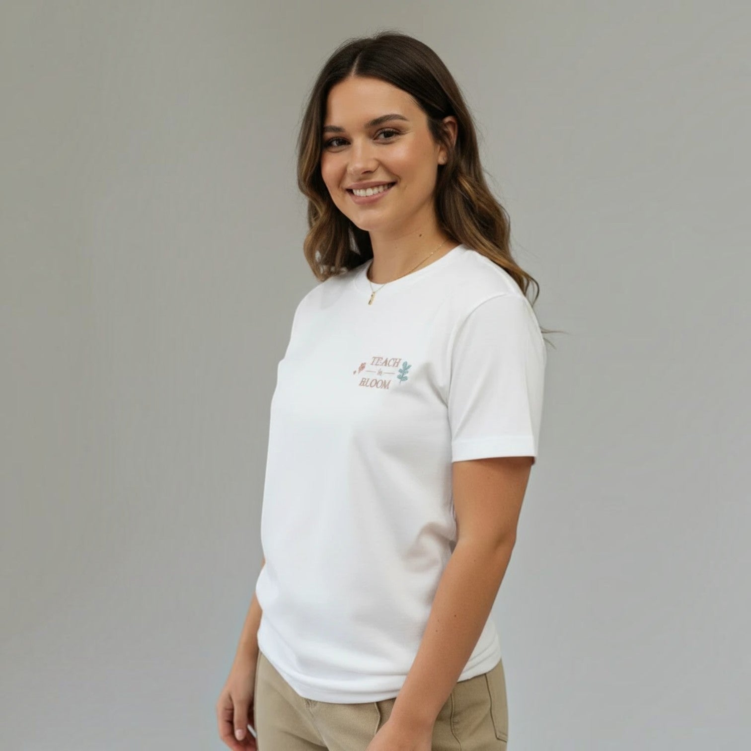 SuYa Shop white cotton t-shirt for teachers with Teach and Bloom embroidery on a smiling woman