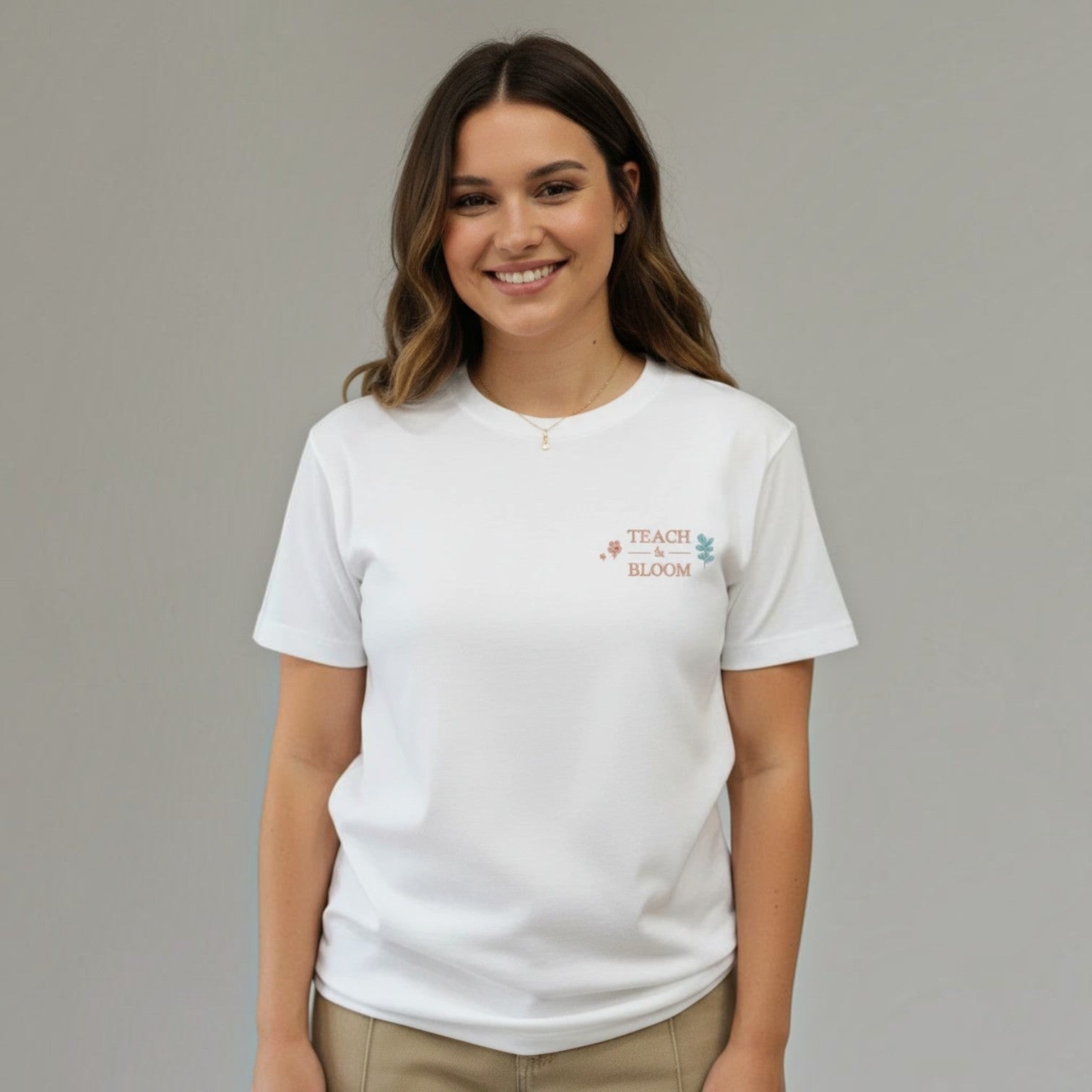 Woman wearing a white SuYa Shop t-shirt with Teach and Bloom embroidery for teachers