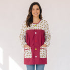 Mujer sonriente vistiendo bata SuYa Shop color granate con estampado de aguacates y botones de colores