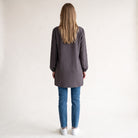 Vista trasera de bata antiarrugas SuYa Shop color gris con mangas largas, combinada con vaqueros y zapatillas
