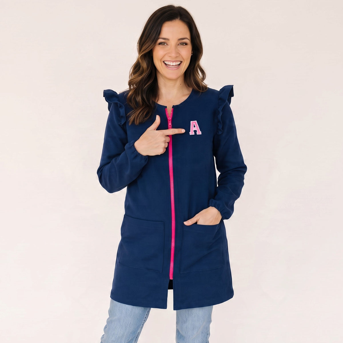 Mujer sonriente vistiendo bata azul marino SuYa Shop con cremallera rosa, volantes en hombros y letra personalizada