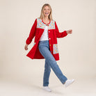 Modelo sonriente vistiendo bata escolar roja SuYa Shop con estampado de motivos escolares y botones frontales