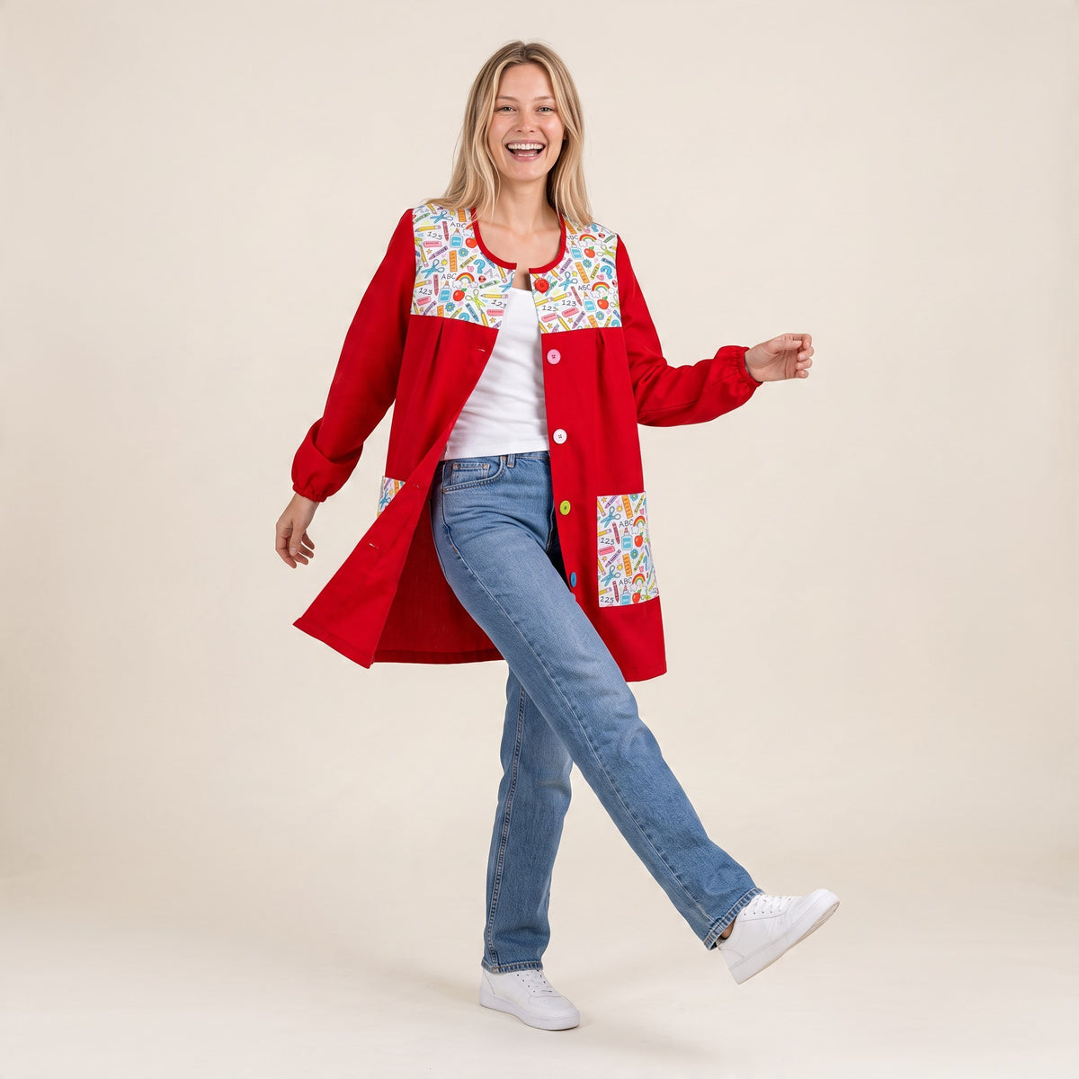 Modelo sonriente vistiendo bata escolar roja SuYa Shop con estampado de motivos escolares y botones frontales