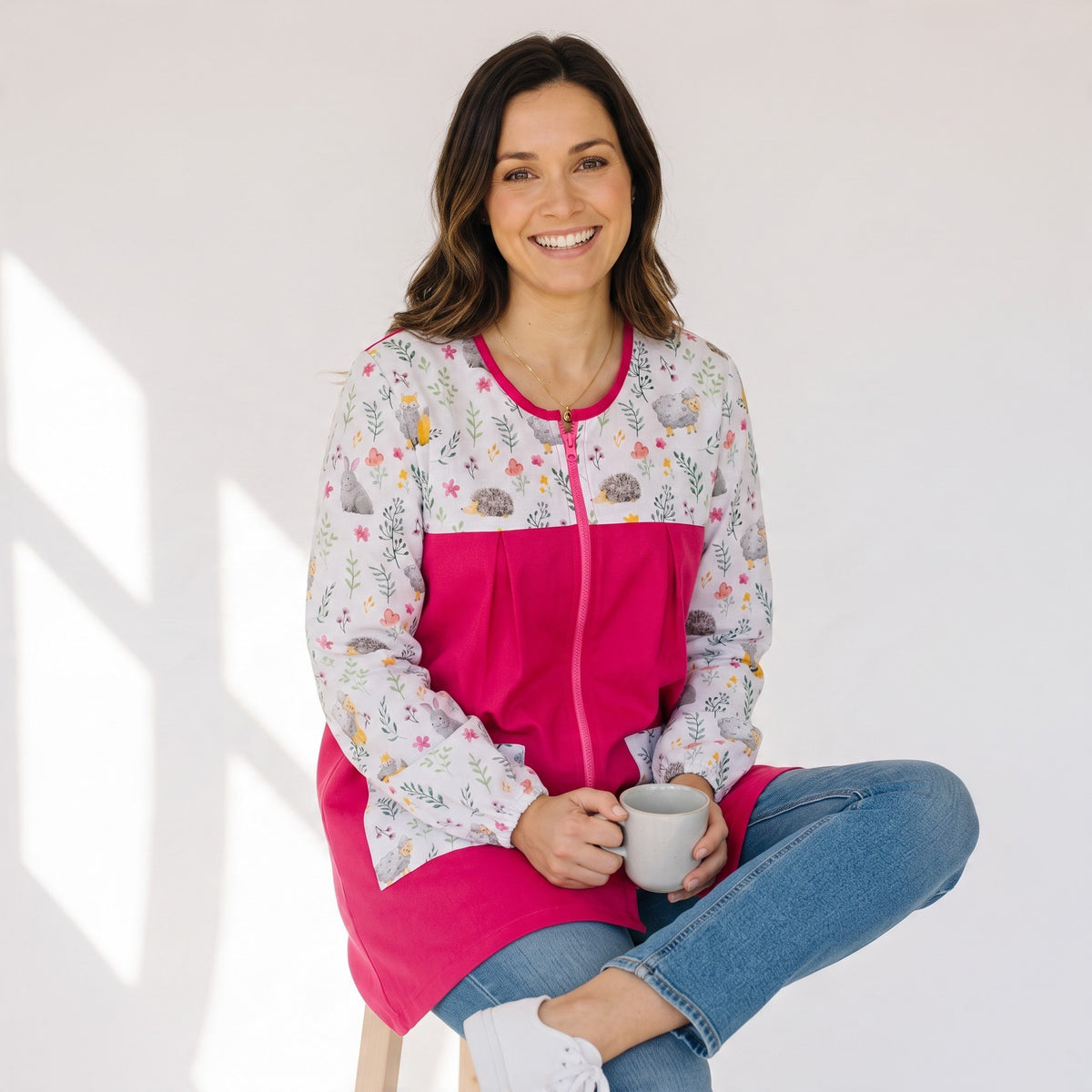 Mujer sonriente vistiendo bata SuYa Shop de manga larga con estampado floral y de erizos en tonos fucsia y blanco