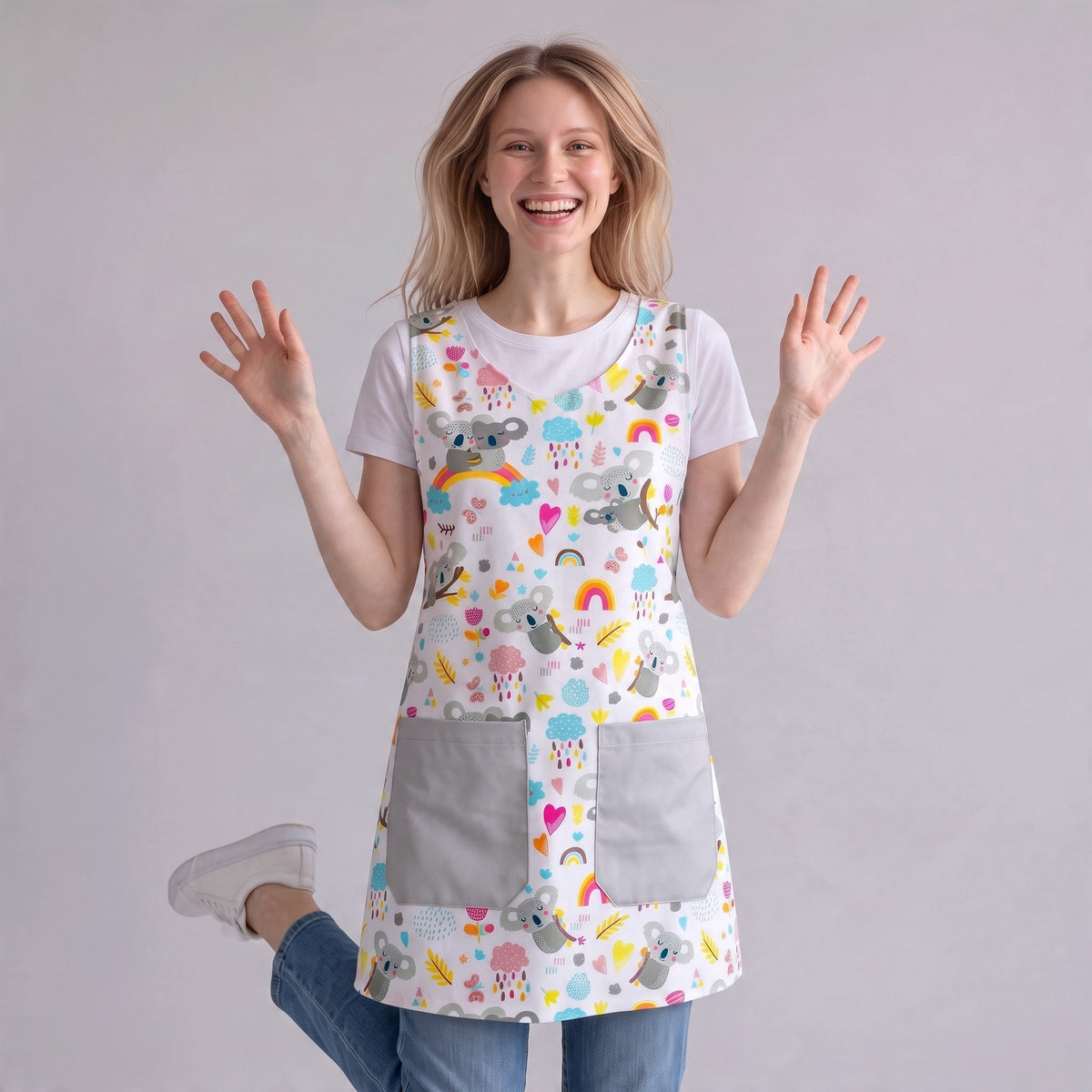 Bata maestra SuYa Shop blanca con estampado de koalas, arcoíris y corazones, con dos bolsillos frontales grises.