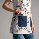 Bata de professora SuYa Shop com estampado de pinguins, balões e aviões, com bolsos frontais azul-marinho.