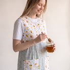 Bata de maestra SuYa Shop con estampado de margaritas y abejas sobre fondo de cuadros vichy verde y blanco