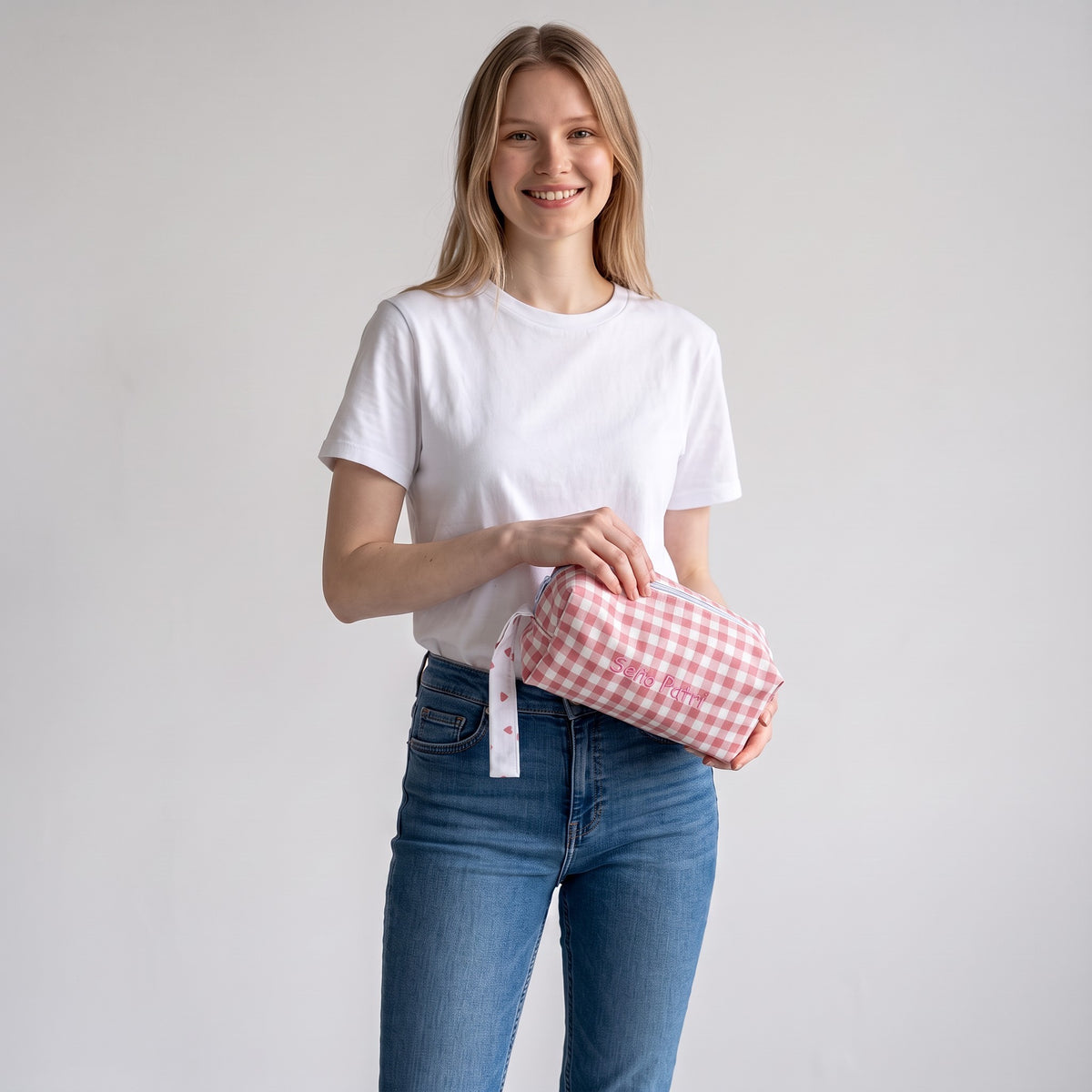 Donna che tiene un astuccio SuYa Shop maxi con quadretti vichy rosa e bianchi, ideale come pochette da toilette.