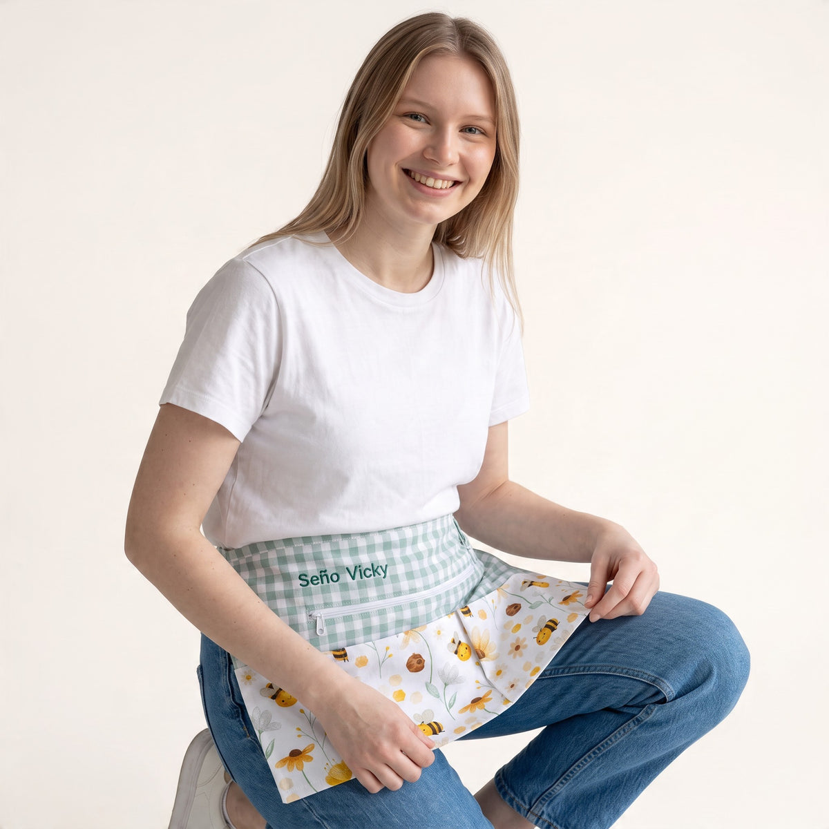 Mujer sonriente usando mandil SuYa Shop personalizado con estampado de abejas, flores y bolsillo con cremallera.