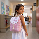 SuYa Shop personalized pink gingham backpack with heart pattern worn by a young girl in a school hallway