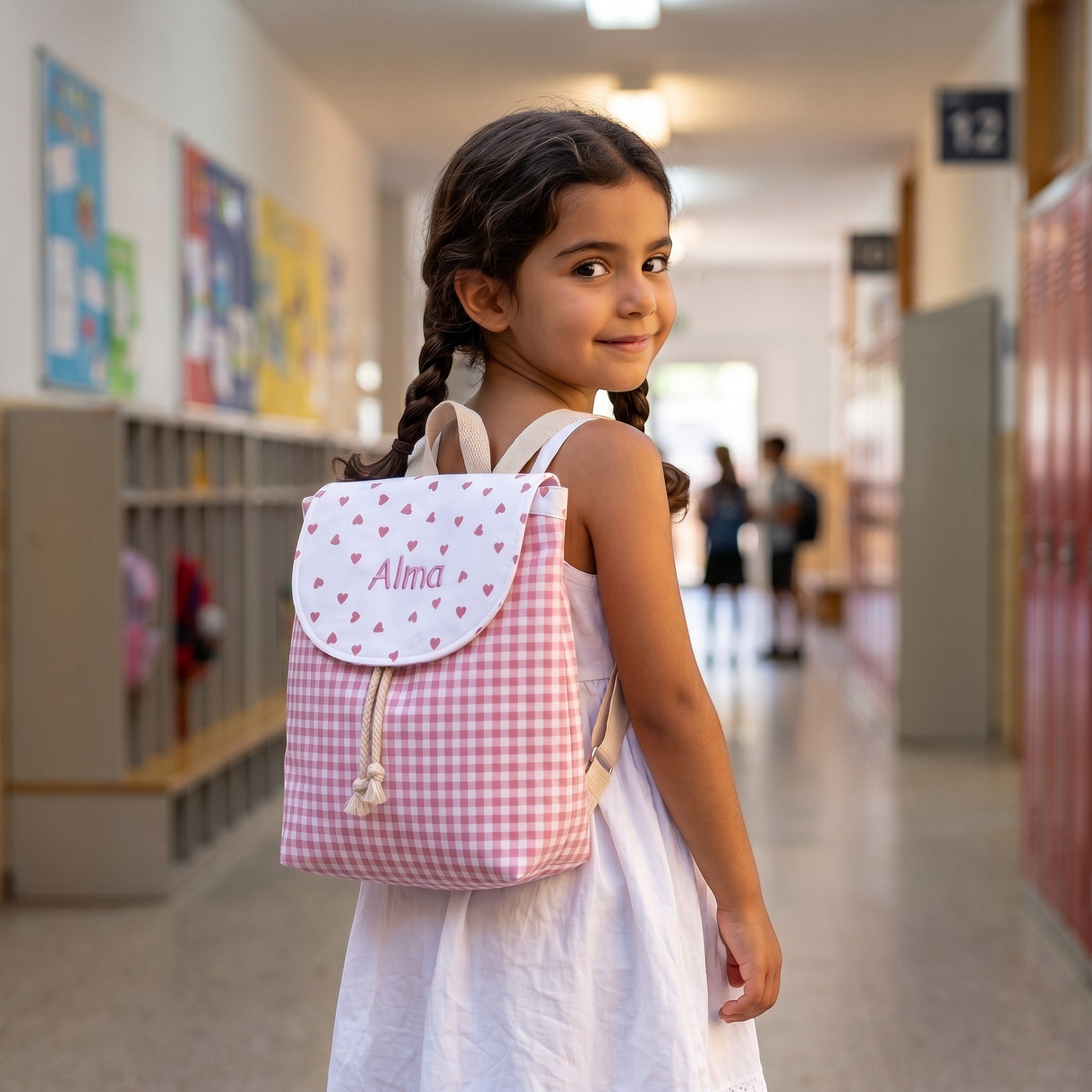SuYa Shop personalized pink gingham backpack with heart pattern worn by a young girl in a school hallway