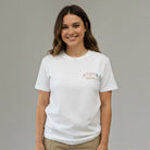 Woman wearing a white SuYa Shop t-shirt with Teach and Bloom embroidery for teachers